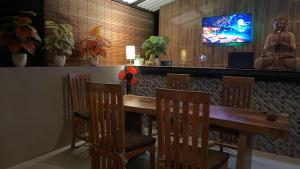 a dining room with a wooden table and chairs at Green Merta in Padangbai