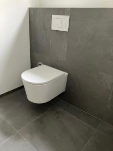 a white toilet in a bathroom with a wall at Rue118 in Essen