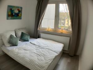 a small bed in a room with a window at Rue118 in Essen