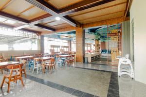 a dining room with wooden tables and chairs at Azana BeSt Hotel Batu in Tlekung