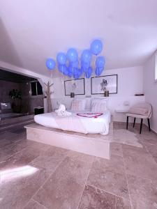 a bedroom with blue balloons hanging above a bed at Suite Prestige in Codolet