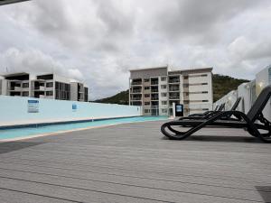 a row of chairs sitting on the side of a swimming pool at TJ Homes in Ross Island