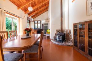 a dining room with a table and a fireplace at The Church Accommodation in Hahei