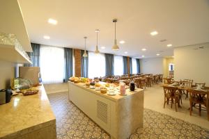 - un restaurant avec des tables et des chaises dans une salle dans l'établissement Moinho Itália Hotel, à Campos do Jordão