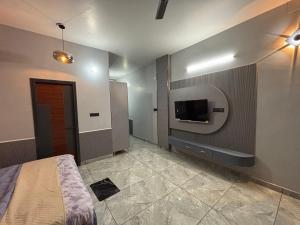 a bedroom with a bed and a tv on a wall at GardenView Hotel and Resort in Dhantori