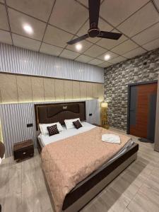 a bedroom with a large bed and a ceiling fan at GardenView Hotel and Resort in Dhantori