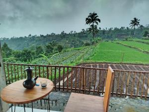 a table on a balcony with a view of a field at Sunset Homestay in Sapit