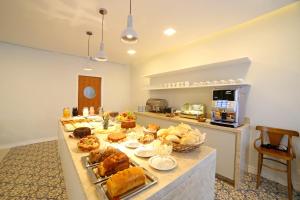 a table with many different types of food on it at Moinho Itália Hotel in Campos do Jordão +34 photos
