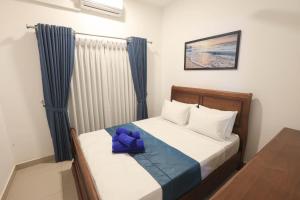 a bedroom with a bed with a blue bow on it at Santorini Negombo in Negombo +15 photos