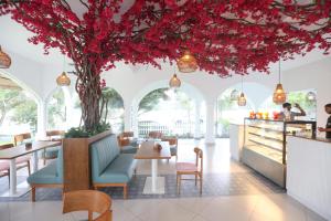 a restaurant with red flowers hanging from the ceiling at Santorini Negombo in Negombo