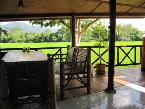 a table and chairs on a porch with a view of a field at XPai in Pai