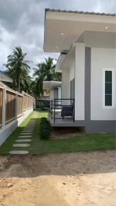 a house with a bench on the side of it at jessi house pool in Ban Nok
