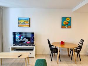 a living room with a table and a tv at New Town Studio in Sydney
