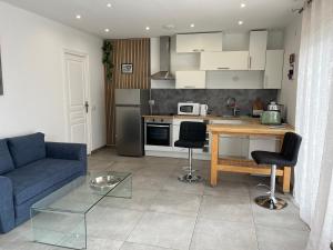 a living room with a blue couch and a kitchen at La Détente in Bonifacio +8 photos