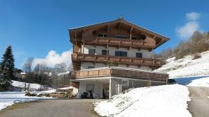 ein Haus im Schnee auf einem Berg in der Unterkunft Appartement Maurer in Niederau