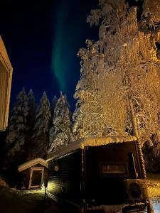 an rv parked in front of a forest of snow covered trees at Santa Elves Cabin in Rovaniemi