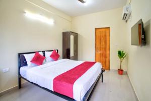 a bedroom with a large bed with red pillows at Casa Nathan in Calangute