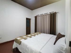 a bedroom with a large white bed in a room at Felix Holiday Bungalow in Ella