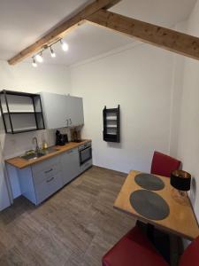 a kitchen with a table and a counter top at Maimühle Appartements in Perl +3 photos