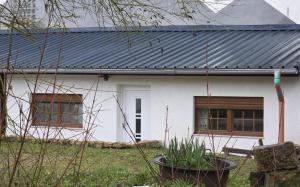 a white house with a black metal roof at Maimühle Appartements in Perl