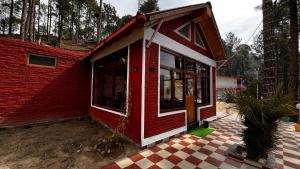 a red and white house with a checkered floor at Hidden Mountain Resort in Almora