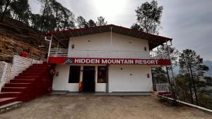 ahidden mountain resort sign on the side of a building at Hidden Mountain Resort in Almora