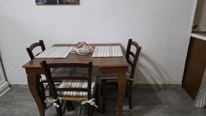 a dining room table with chairs and a table at Casa Nicole in Assemini