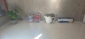 a shelf with a cup and a plant on it at Holiday Home in Warrnambool in Warrnambool