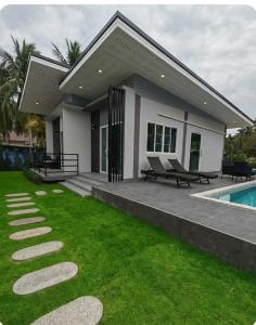a house with a lawn and a swimming pool at jessi house pool in Ban Nok