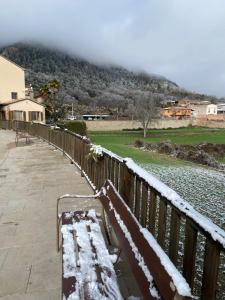 a bench covered in snow next to a fence at Raconet de Peramola in Peramola