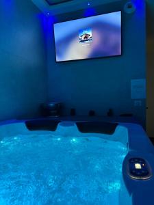 a hot tub with a tv in a room at Hammam du château in Francheville