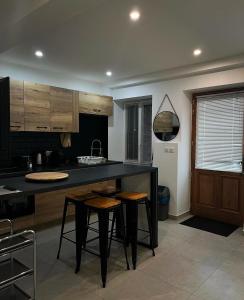 a kitchen with a black counter and some stools at Hammam du château in Francheville