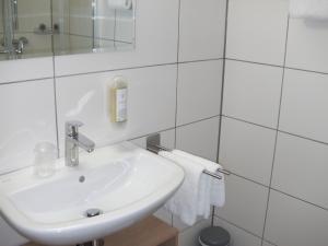 a white bathroom with a sink and a mirror at Kemnater Hof Apartments SELF-CHECK-IN in Ostfildern
