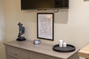 a table with a statue and a picture on a wall at Curzon St Aparthotel in Derby