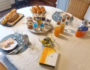 a table with breakfast foods and orange juice on it at Les 2 Ginkgos à 5 minutes de Beauval in Seigy