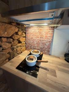 two pots and pans on a counter with a brick wall at Monte Vilão in Soudes +39 photos