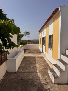 a building with yellow and white walls and stairs at Monte Vilão in Soudes