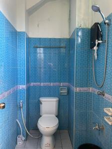 a blue bathroom with a toilet and a shower at GSB City Apartelle in Tuguegarao City +21 photos