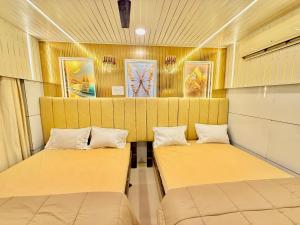 two beds in the back of a room at Hotel rajmahel chotila in Chotila