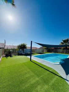 a swimming pool with a volleyball net in a yard at Ocean View Villas in Geraldton