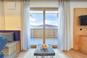 a living room with a table and a large window at Forchnerhof Panorama- Rienzschlucht in Rodengo