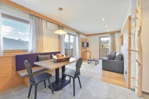a dining room and living room with a table and chairs at Forchnerhof Panorama- Rienzschlucht in Rodengo