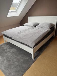 a bed with a white bed frame in a bedroom at Ferienwohnung Schürer in Lauter