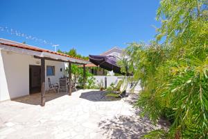 a patio of a house with chairs and a umbrella at Apartments Silva in Sutivan