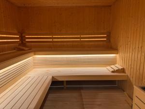 a sauna with a bench in a wooden room at Apartament Mika Let's Sea 73 Tuż przy plaży, klimatyzacja, basen in Gąski