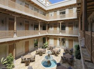 an empty courtyard with tables and chairs in a building at Zumrad Boutique Hotel in Bukhara