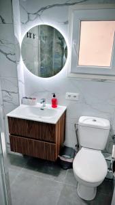 a bathroom with a toilet and a sink and a mirror at Apartamento Cabrera Burriac in Cabrera de Mar +16 photos