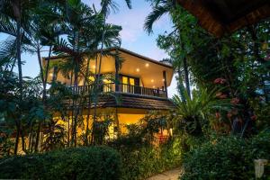 a house with a balcony on the side of it at Gajah Biru Bungalows in Ubud