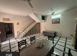 a dining room with a table and a staircase at Shree Govindam kunj Villa in Jaipur