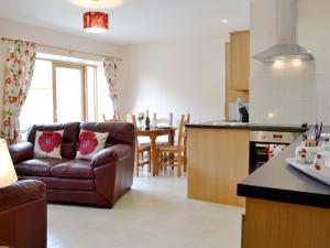 a kitchen and living room with a couch and a table at The Dairy - Op3 in Carmarthen